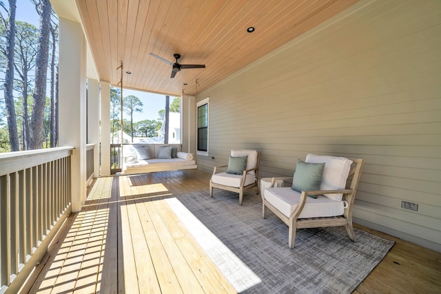 wooden terrace with ceiling fan and an outdoor hangout area