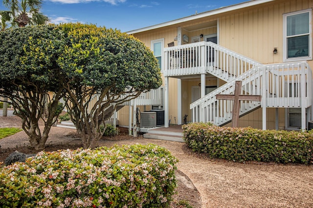 view of front of home with central AC and a balcony