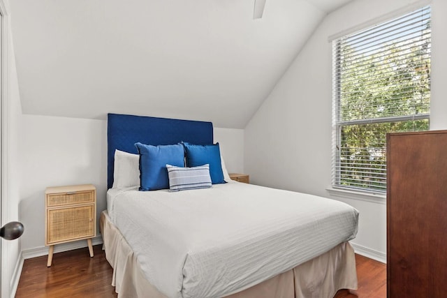 bedroom featuring ceiling fan, lofted ceiling, dark hardwood / wood-style flooring, and multiple windows