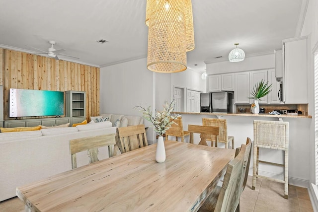 dining area featuring ceiling fan with notable chandelier, crown molding, and light tile flooring