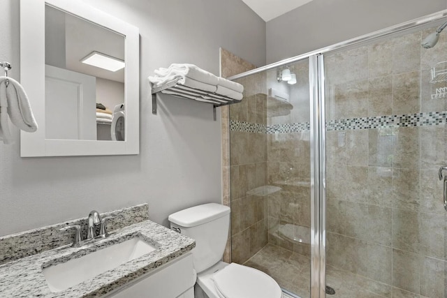 bathroom with vanity, toilet, and a shower with shower door