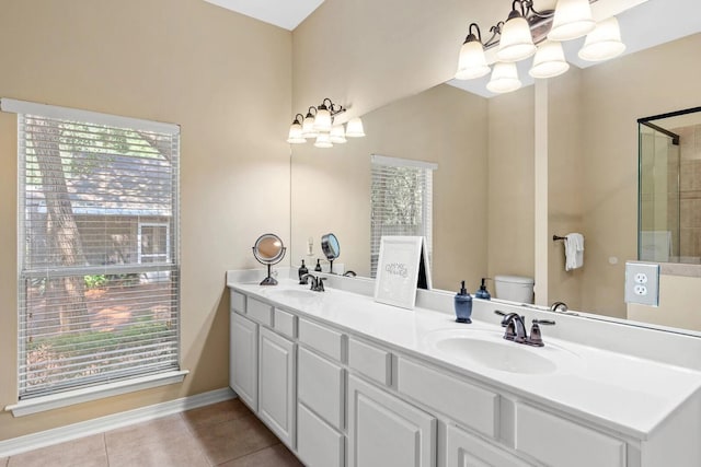 bathroom featuring plenty of natural light, tile floors, oversized vanity, dual sinks, and toilet