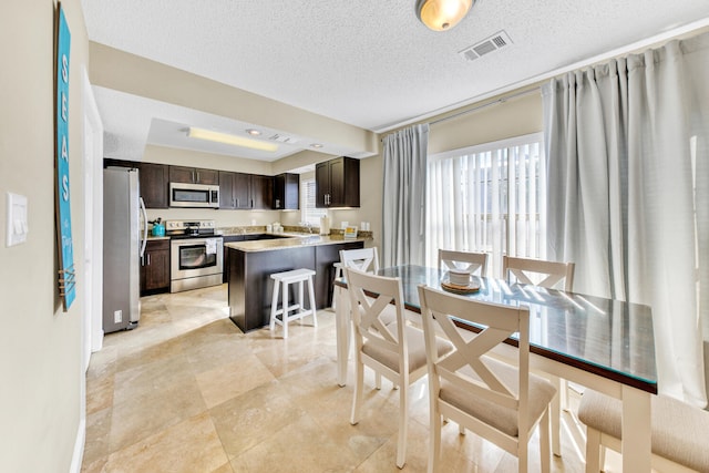 dining space with a textured ceiling and light tile flooring