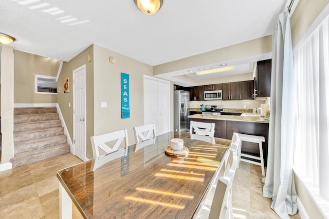 dining room with a textured ceiling and light tile floors