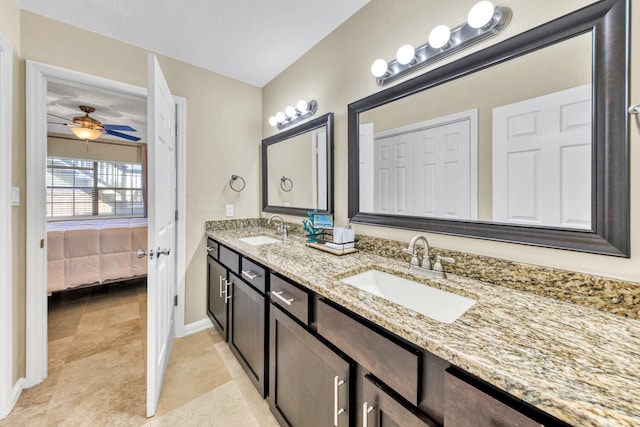 bathroom featuring large vanity, double sink, tile flooring, ceiling fan, and a textured ceiling