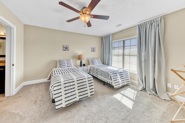 carpeted bedroom featuring ceiling fan and a textured ceiling