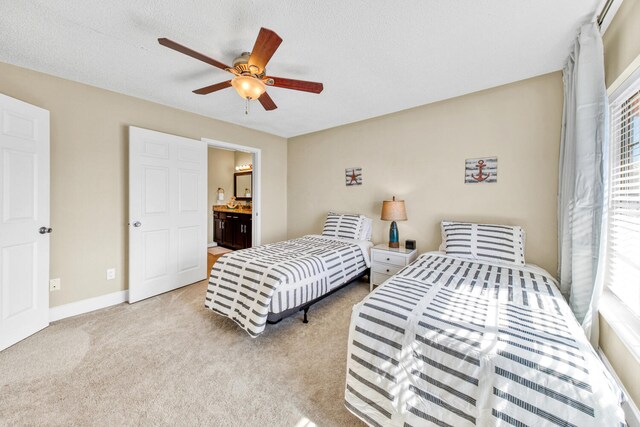 carpeted bedroom featuring connected bathroom, ceiling fan, and a textured ceiling