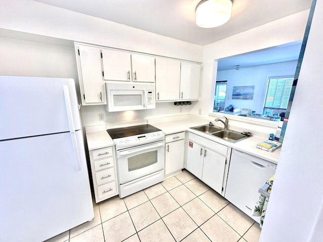 kitchen with sink, white cabinets, light tile patterned flooring, and white appliances