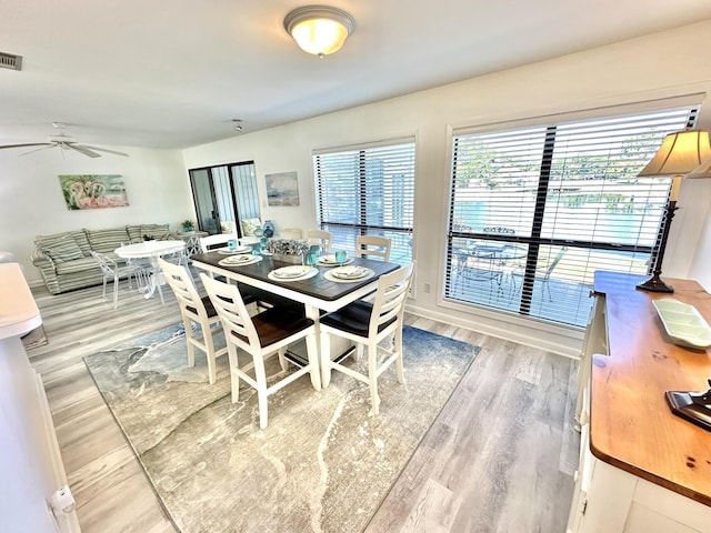 dining area with ceiling fan and wood-type flooring