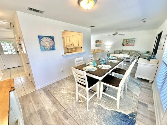 dining space with ceiling fan and light wood-type flooring