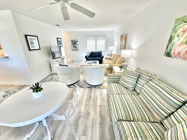 living room featuring ceiling fan and light hardwood / wood-style flooring