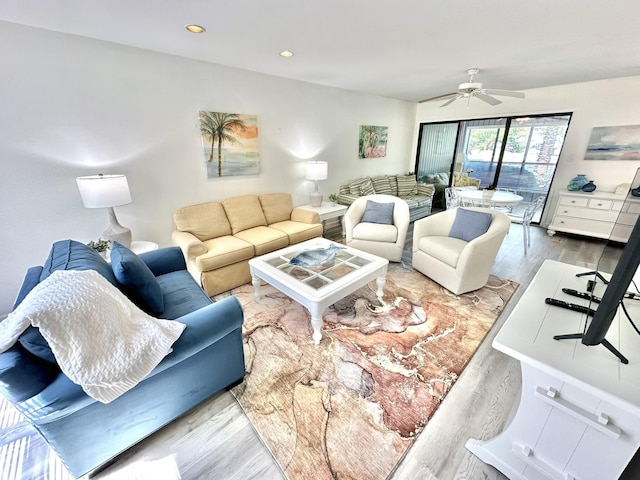 living room featuring ceiling fan and light hardwood / wood-style flooring