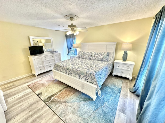 bedroom featuring ceiling fan, a textured ceiling, and light hardwood / wood-style flooring