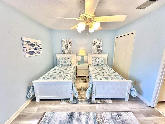 bedroom with a closet, ceiling fan, and light hardwood / wood-style floors