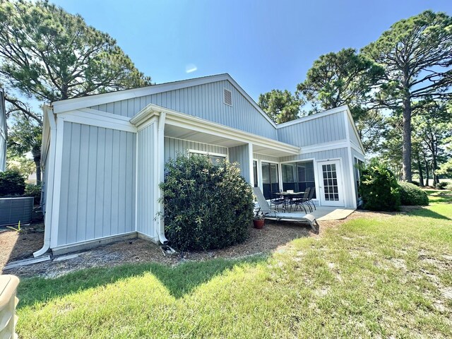 back of property with a lawn, cooling unit, and a patio