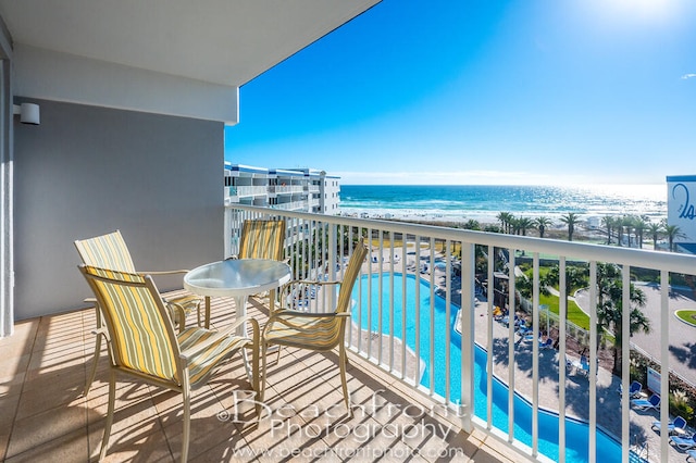 balcony featuring a water view and a community pool