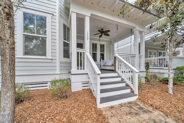 entrance to property with ceiling fan and a porch