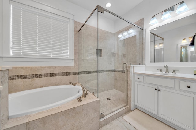 bathroom with plus walk in shower, vanity with extensive cabinet space, and tile flooring