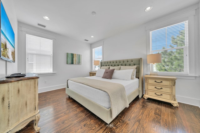 bedroom with dark hardwood / wood-style flooring and multiple windows