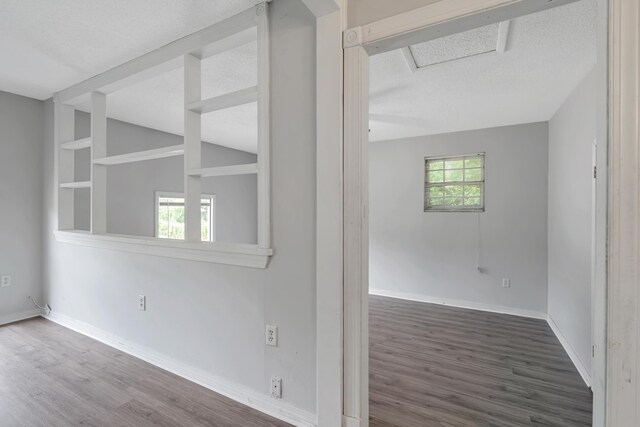 empty room with dark wood-type flooring and a textured ceiling