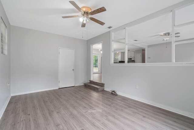 spare room featuring light hardwood / wood-style flooring and ceiling fan