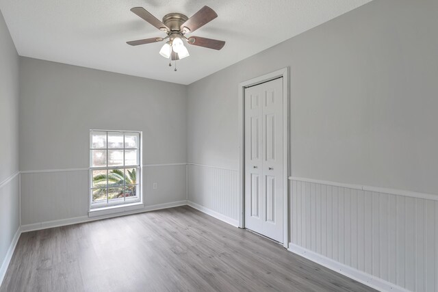 empty room with ceiling fan and light hardwood / wood-style floors