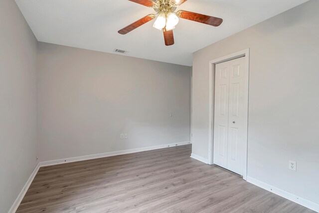 unfurnished bedroom with a closet, light hardwood / wood-style flooring, and ceiling fan