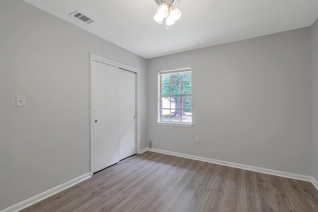 unfurnished bedroom with light hardwood / wood-style floors and a closet