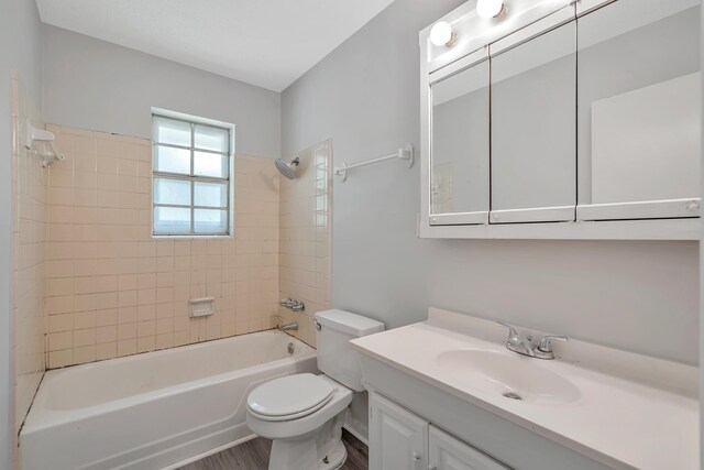 full bathroom with vanity, tiled shower / bath combo, and toilet