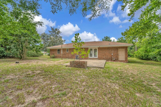 rear view of property with a lawn, a patio area, and french doors