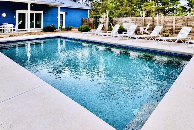 view of pool with french doors and a patio area