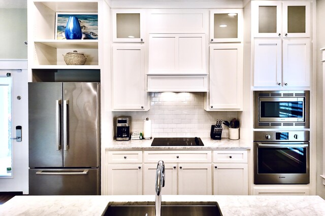 kitchen featuring white cabinetry, sink, light stone countertops, and appliances with stainless steel finishes