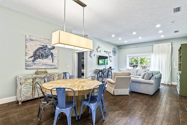 dining space featuring a textured ceiling and dark hardwood / wood-style flooring