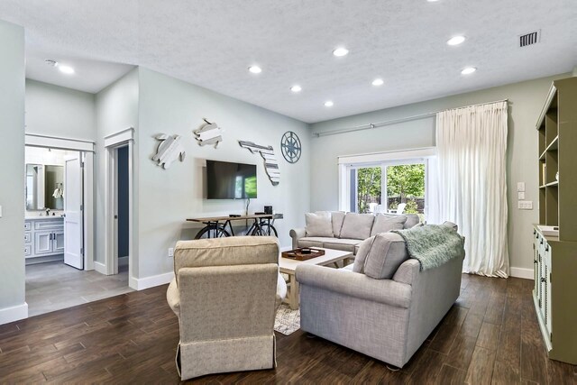 living room with dark wood-type flooring and a textured ceiling