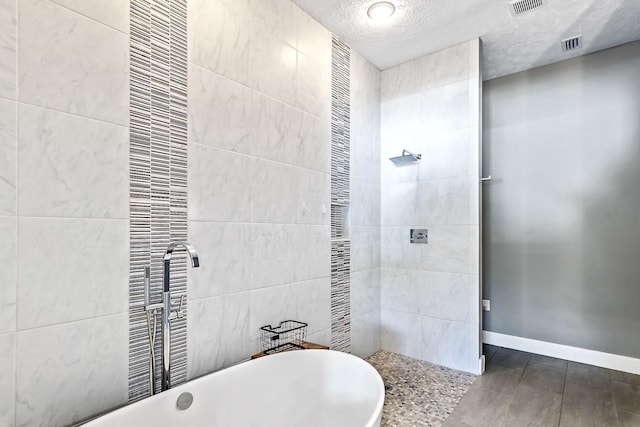 bathroom featuring shower with separate bathtub and a textured ceiling