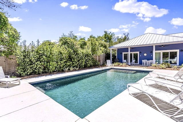 view of swimming pool featuring french doors, ceiling fan, and a patio