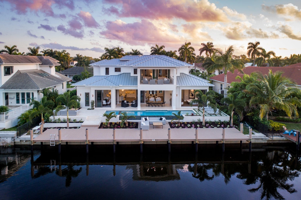 back house at dusk featuring a fenced in pool and a patio area