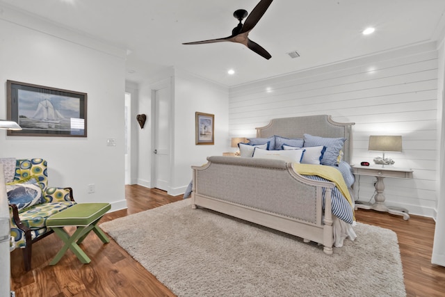 bedroom with ceiling fan, ornamental molding, and dark hardwood / wood-style floors