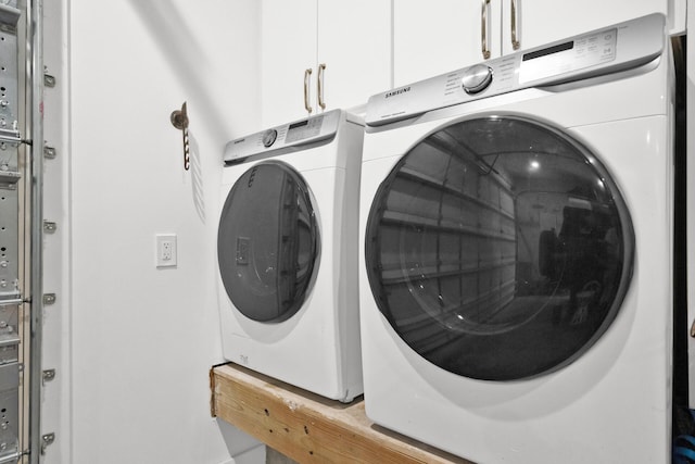 laundry room featuring washing machine and dryer and cabinets