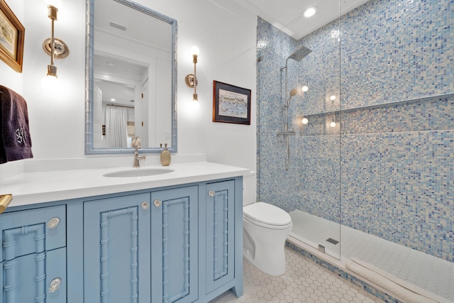 bathroom with vanity, tile patterned floors, toilet, and tiled shower