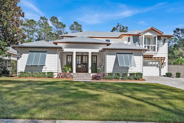 view of front of house featuring a garage, a front yard, and french doors