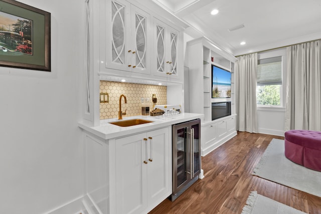 kitchen with sink, white cabinetry, backsplash, wine cooler, and stainless steel oven