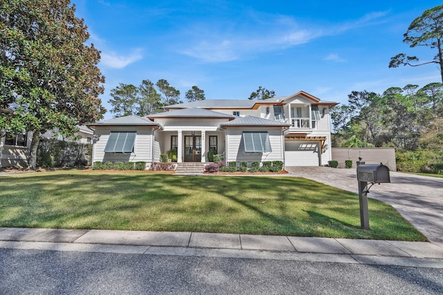 view of front of house featuring a garage, covered porch, and a front lawn