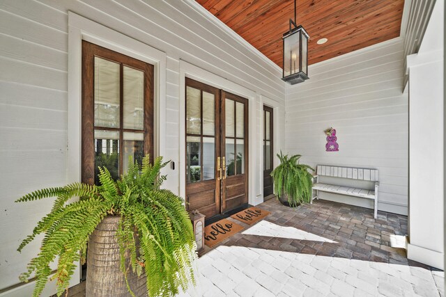 view of exterior entry featuring covered porch and french doors