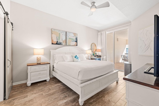 bedroom with a textured ceiling, ceiling fan, and a barn door