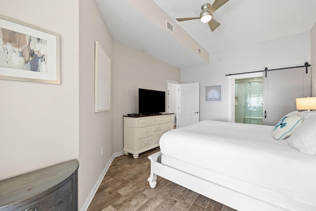 bedroom with ceiling fan, hardwood / wood-style flooring, and a barn door