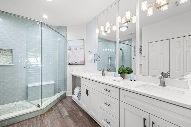 bathroom featuring wood-type flooring, a shower with door, and vanity