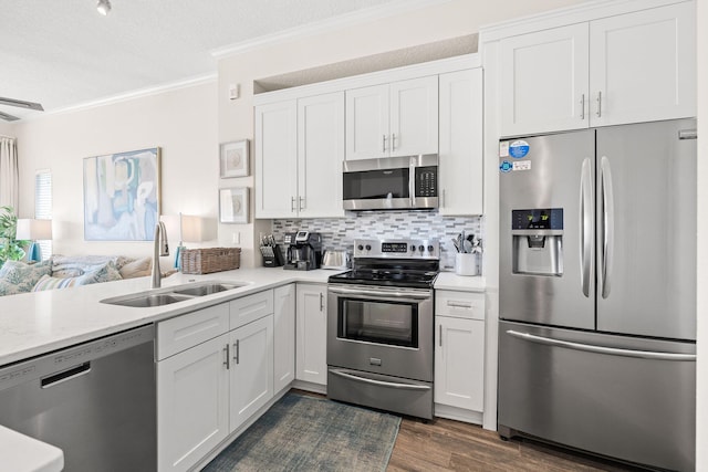 kitchen featuring stainless steel appliances, decorative backsplash, dark hardwood / wood-style flooring, white cabinets, and sink