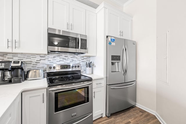 kitchen with decorative backsplash, white cabinetry, appliances with stainless steel finishes, dark hardwood / wood-style flooring, and light stone counters