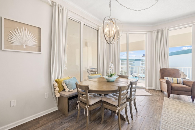 dining space featuring dark hardwood / wood-style flooring, crown molding, and a notable chandelier